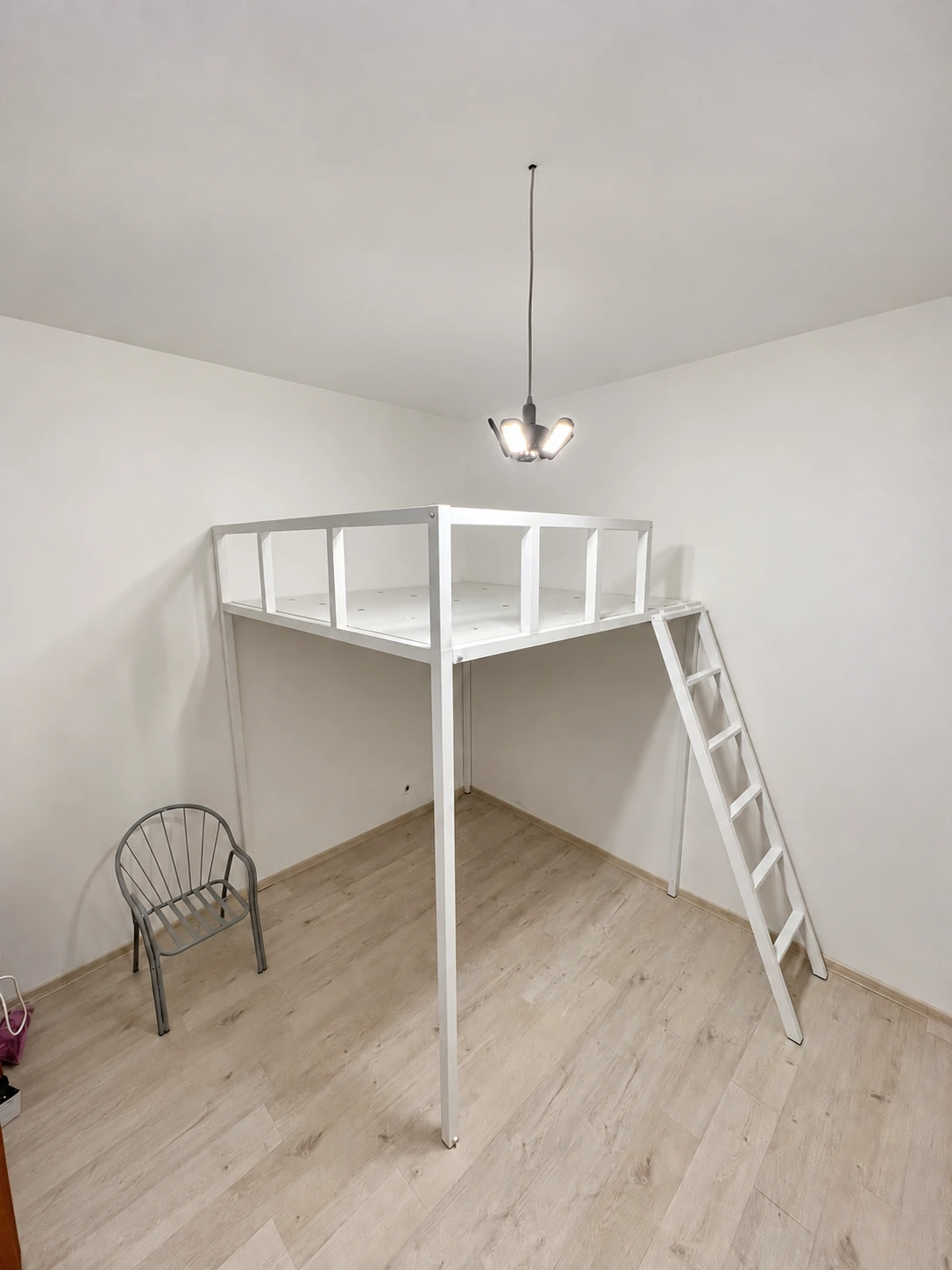 White metal double bed without a mattress — overall side view